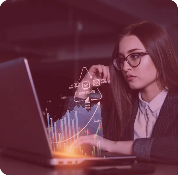 A group of people sitting around a table working on a laptop.