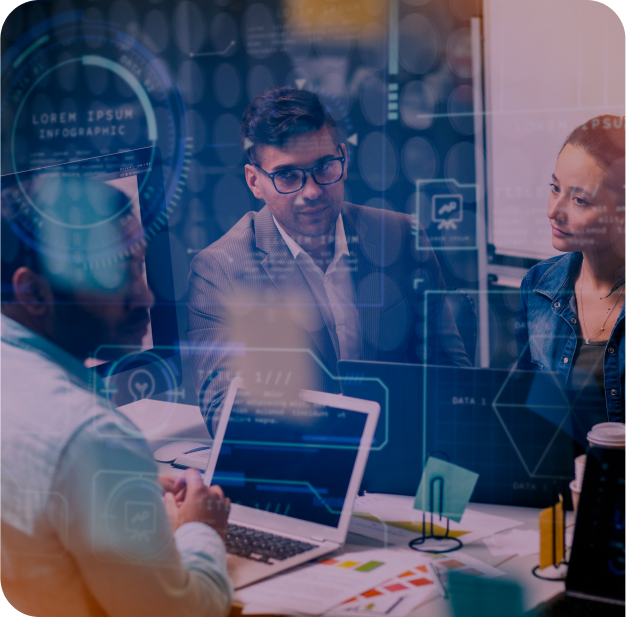 A group of people sitting around a table working on a laptop.
