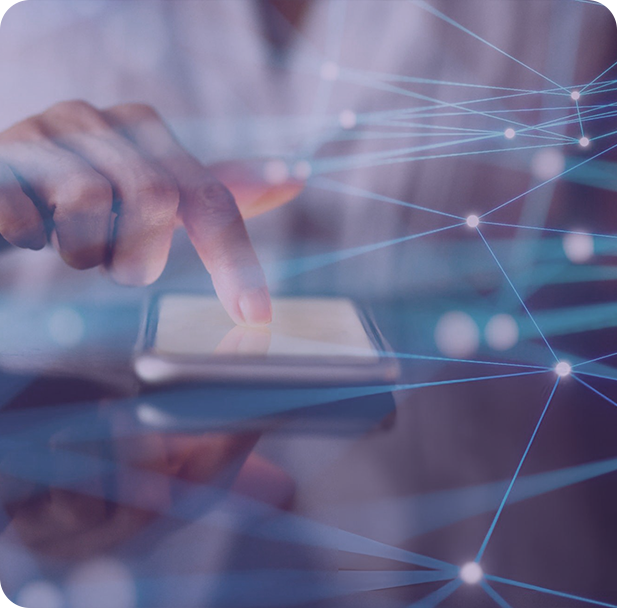 A group of people sitting around a table working on a laptop.